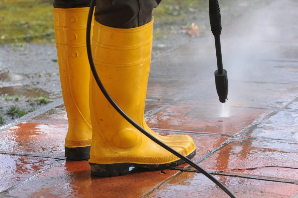 person-wearing-yellow-rubber-boots-with-high-pressure-water-nozzle-cleaning-dirt-tiles person wearing yellow rubber boots with high pressure water nozzle cleaning dirt tiles
